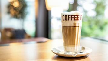 Une tasse de café posée sur une soucoupe, avec une cuillère, le tout sur une table en bois.