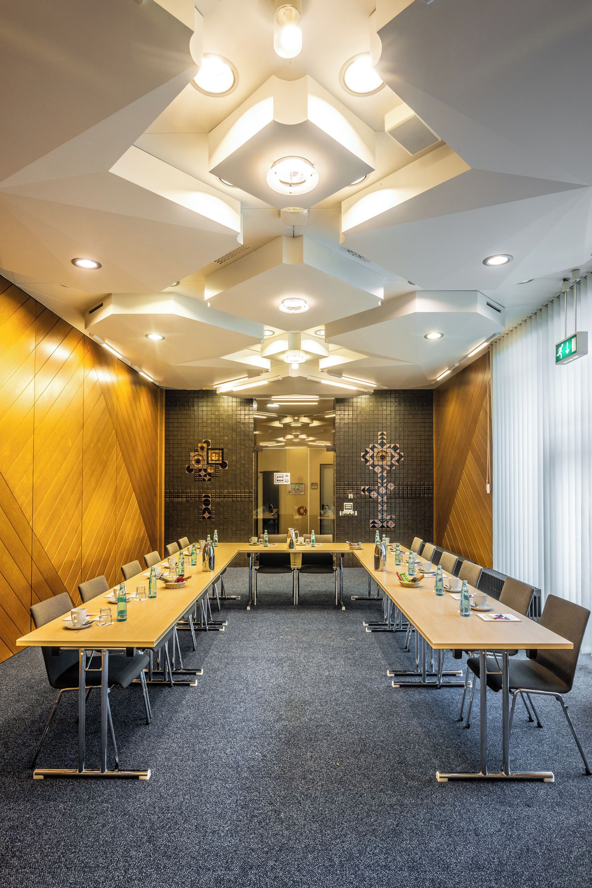 A conference room with a long table, chairs, and ceiling lights.