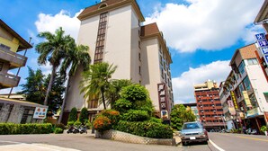 Un hotel alto con un letrero que indica que es un 'Yamazaki Hotel'.