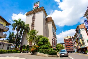 Un hotel alto con un letrero que indica que es un 'Yamazaki Hotel'.