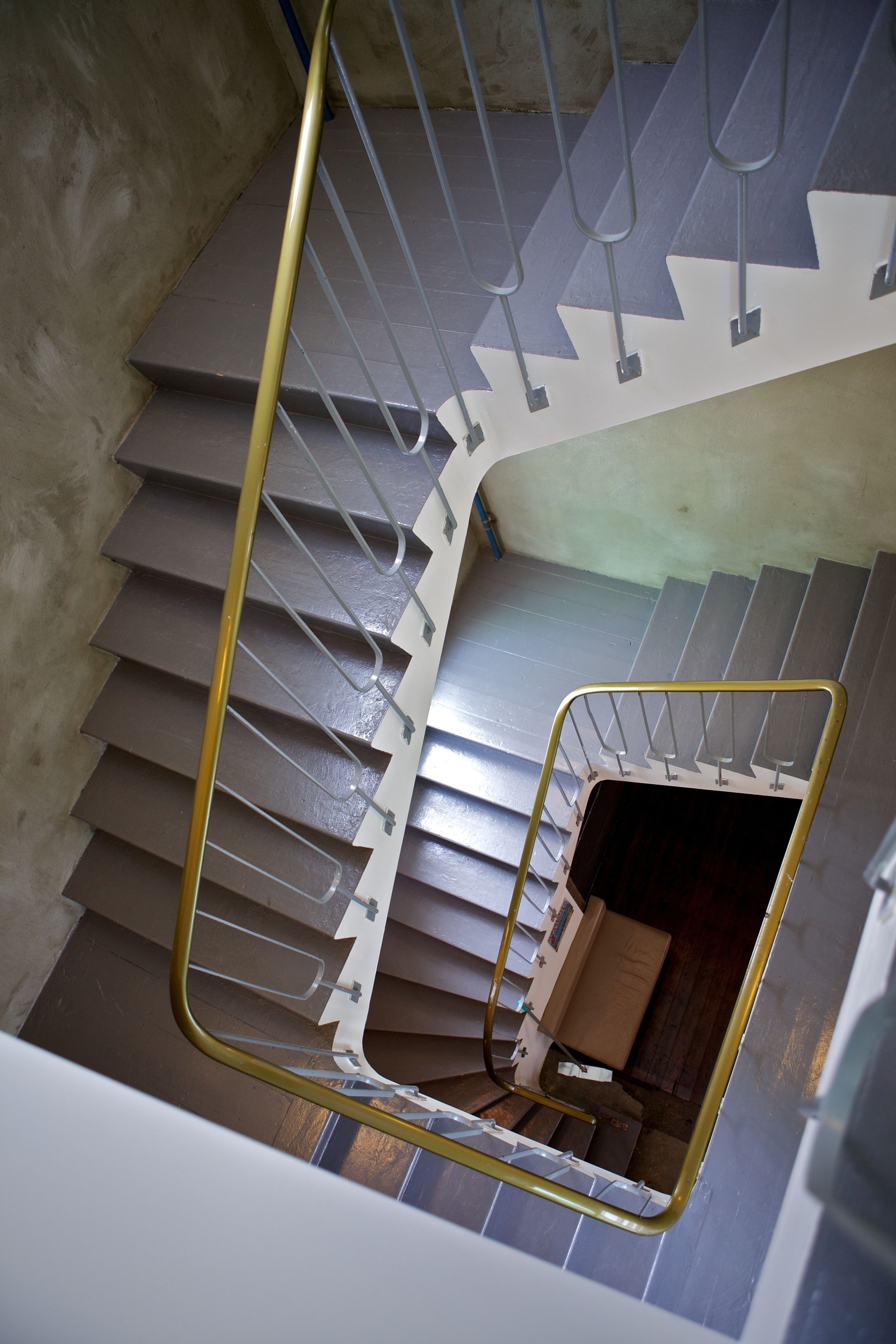 A spiral staircase with metal railings and a handrail.