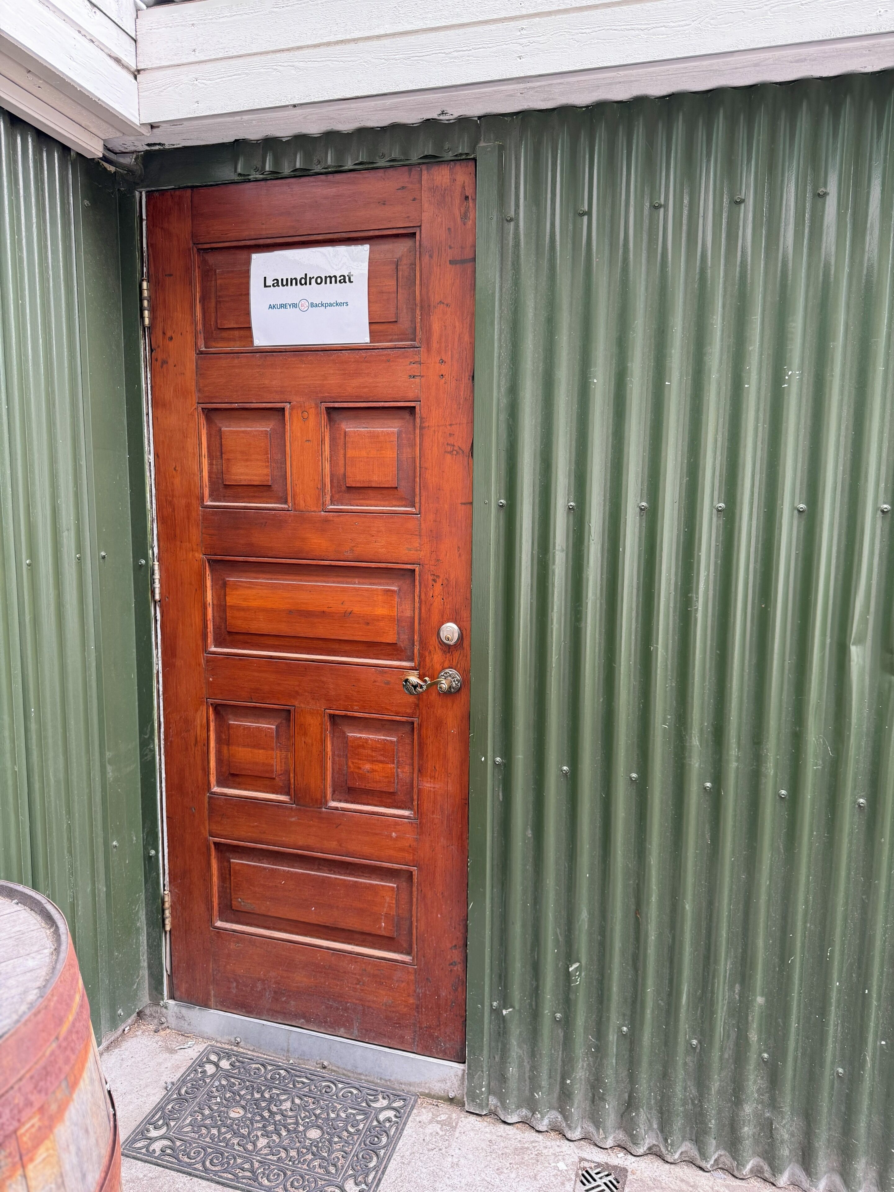A wooden door with a sign reading "Laundromat" and "Akureyri Backpackers."