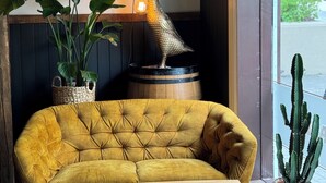 A cozy seating area with a yellow sofa, a wooden table, and a decorative duck lamp. - Akureyri Backpackers (Akureyri)