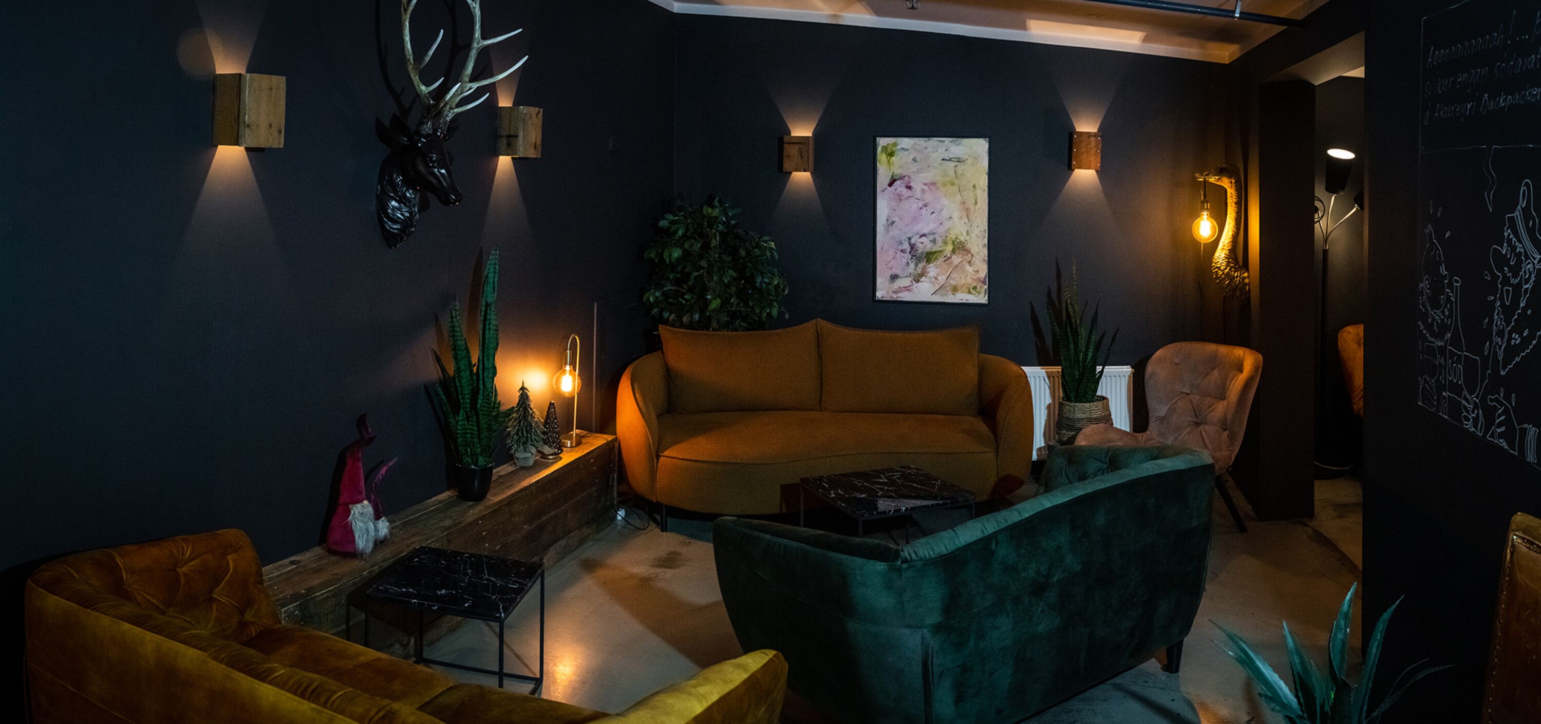A modern living room with a sofa, armchairs, and decorative plants.