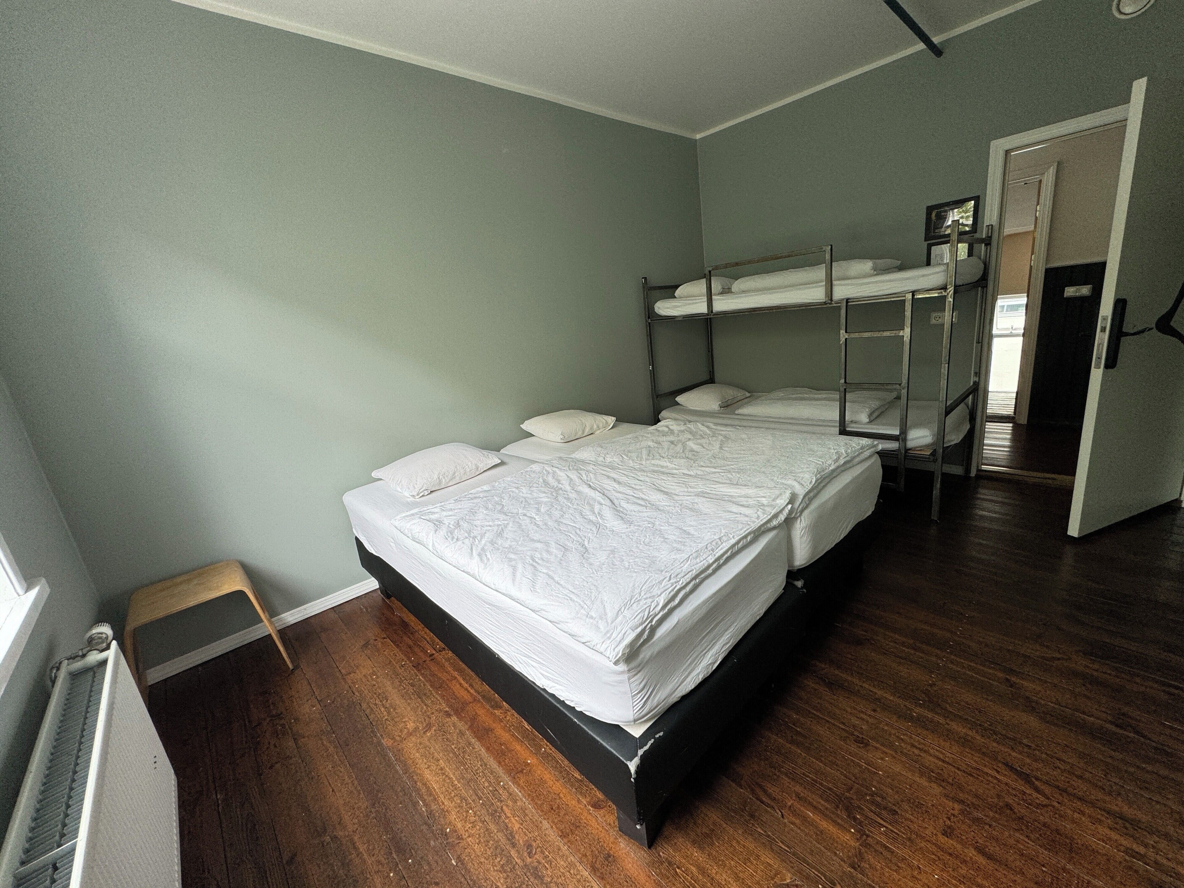 Una habitación con cama, radiador y puerta.