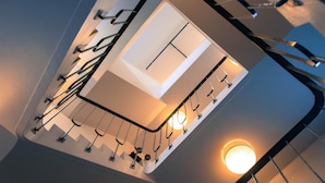 A modern staircase with a glass enclosure and metal railings. - Akureyri Backpackers (Akureyri)