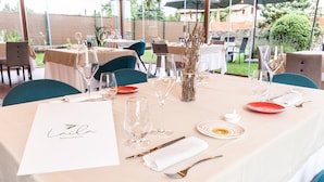 An outdoor dining area with tables set for a meal, including wine glasses, plates, and cutlery. - Hotel Finca Alcamino (Santa Cruz de Bezana)