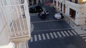 A courtyard with a crosswalk, parked cars, and buildings with balconies. - Casa Cristina (Syracuse)