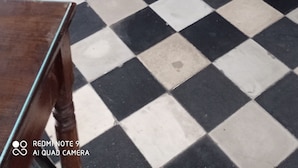 A bedroom with a checkered floor, a wooden bed frame, and a patterned bedspread. - Casa Cristina (Syracuse)