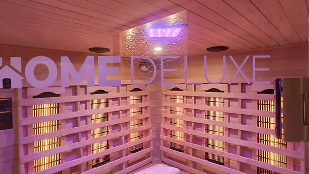 Et receptionsområde med et skilt der viser "HOME DELUXE" og et digitalt ur, der viser tiden.