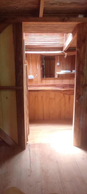 Un intérieur en bois comprenant un espace cuisine, avec des meubles de rangement en bois et un plan de travail.