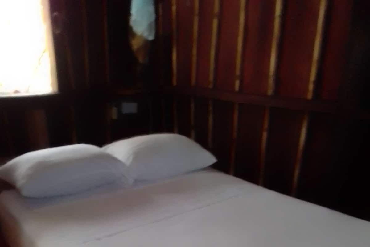 A bed with white bedding and a red skirted base.