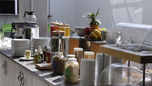 Montaje de bufé con diferentes alimentos, salsas y utensilios para servir.