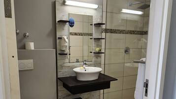 Un baño con inodoro, lavabo y ducha.