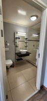 Un baño con inodoro, lavabo y ducha.