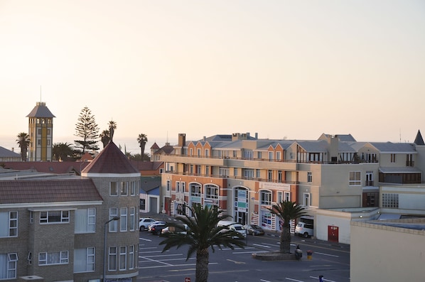 A multi-story building with a mix of architectural styles, including a tower with a pointed roof and a building with a flat roof.