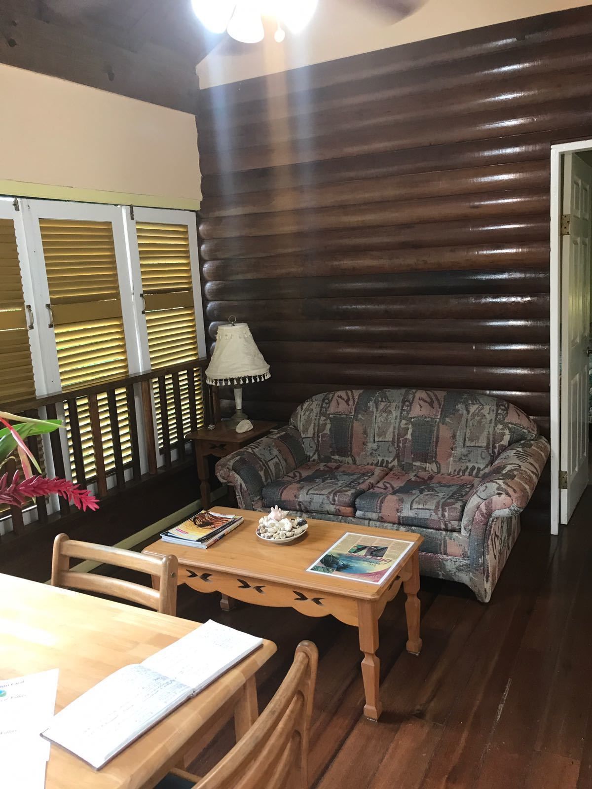 Una sala acogedora con un sofá estampado, una mesa de centro de madera y una lámpara.