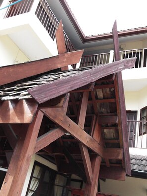 A multi-level wooden staircase with a metal railing, leading to a balcony. - Rim Ping Guesthouse (Chiang Mai)