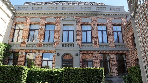A two-story brick building with a symmetrical facade, large windows, and a central entrance with an arched doorway. - Hotel d'Alcantara (Tournai)