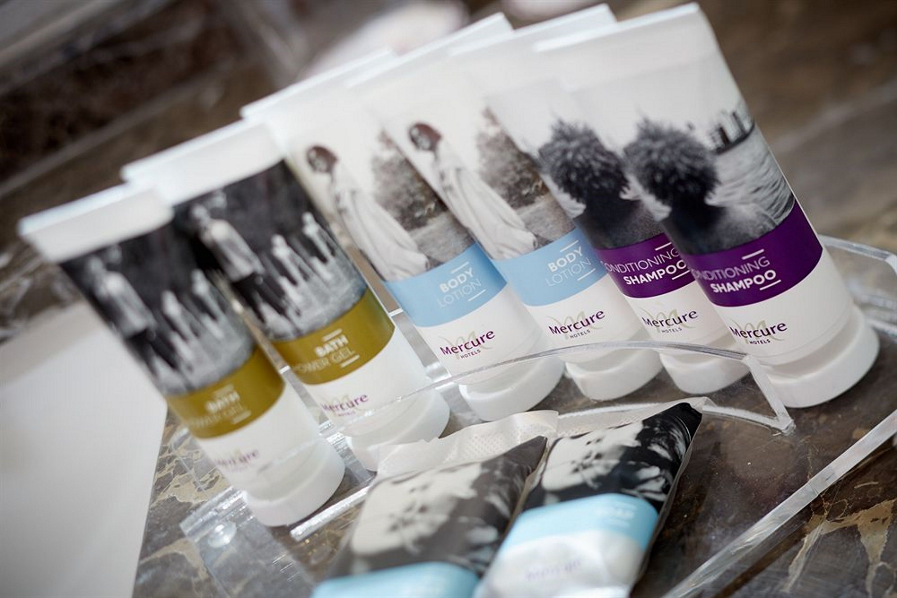 A display of Mercure hotel toiletries including body lotion, shampoo, and conditioner.