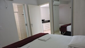 Habitación de hotel con cama, baño y kitchenette.
