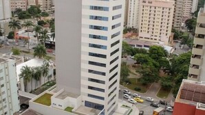 Um edifício alto com design moderno, com vários andares e uma estrutura vertical imponente.