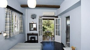 Un dormitorio con una cama, un escritorio, una silla, un televisor y una ventana con cortinas.