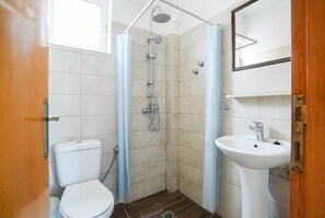 A bathroom with a shower, toilet, and sink. - Peters Kool Pool Studios (Kos)