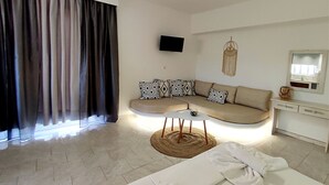 A modern living room with a sofa, a TV, and a decorative wall piece. - Sea Harmony (Rhodes)