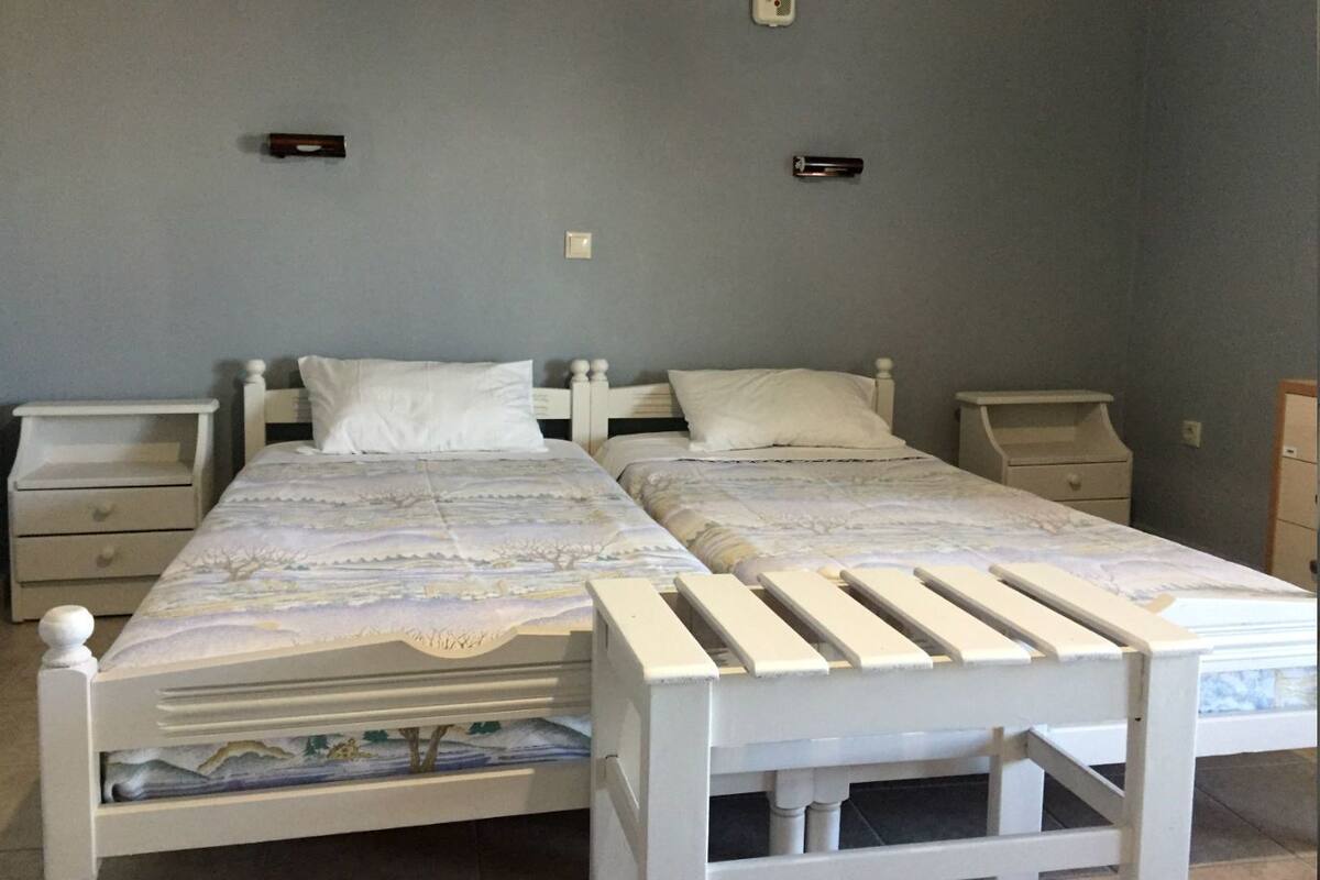 A double bed with a white headboard and footboard, two bedside tables, and a nightstand.
