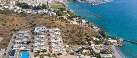 A coastal resort with multiple buildings, a marina, and a beach.