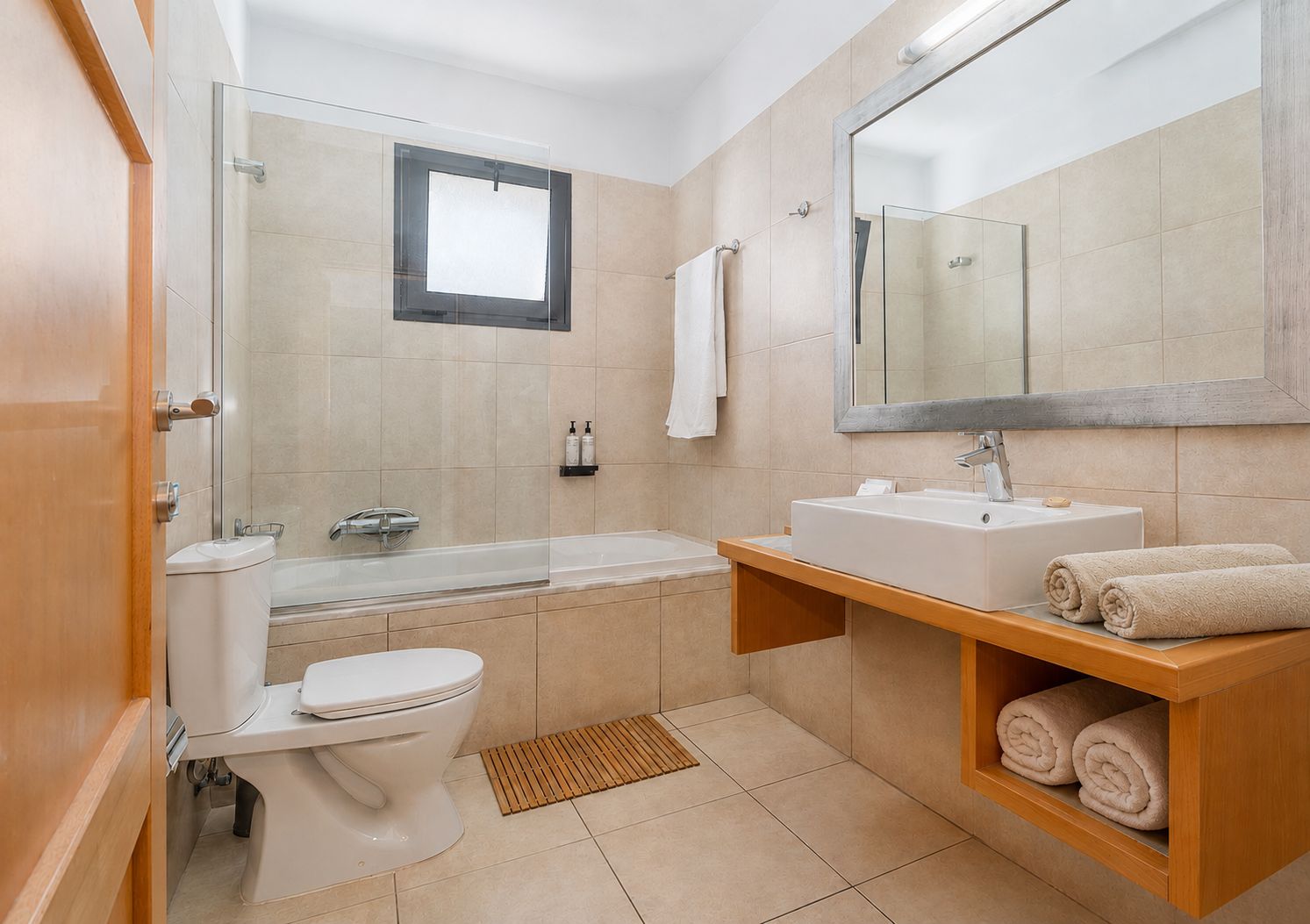 Een moderne badkamer met toilet, wastafel en bad.