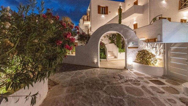 A white building with a stone pathway leading to an archway. - Edem Garden Residence (Mykonos)