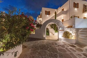 Un edificio blanco con un camino de piedra que conduce a un arco.