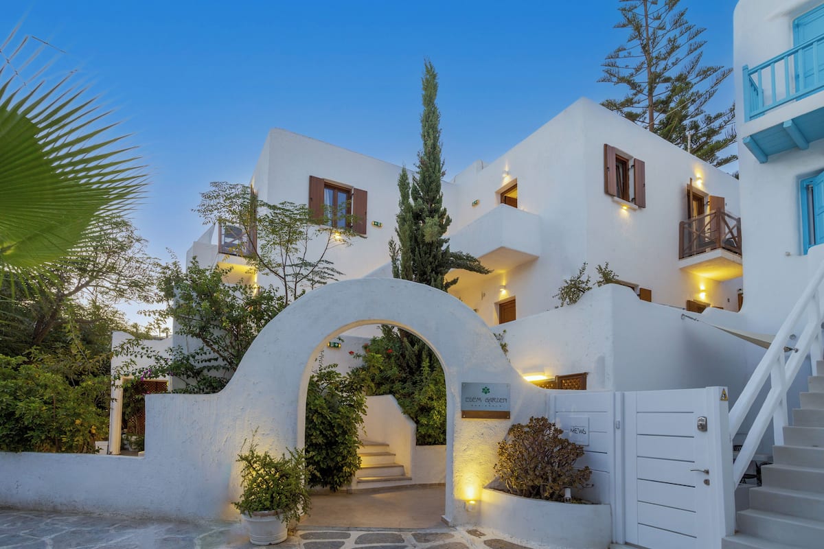 A white building with a staircase, an archway, and a sign that reads 'Eden Garden.'