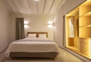 Un dormitorio con una cama, un armario de madera y una ventana con cortinas.