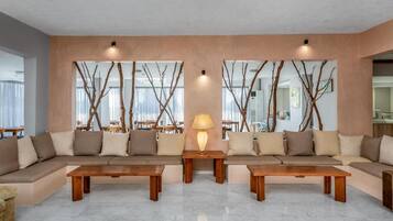 A modern living room with a sectional sofa, two wooden coffee tables, and a lamp.