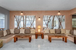 A modern living room with a sectional sofa, two wooden coffee tables, and a lamp. - Afandou Blu (Rhodes)