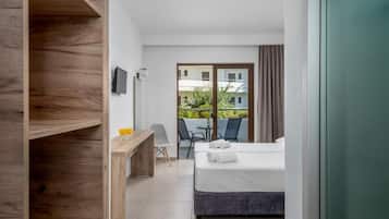 A hotel room with a bed, a desk, a chair, and a view of the outside.