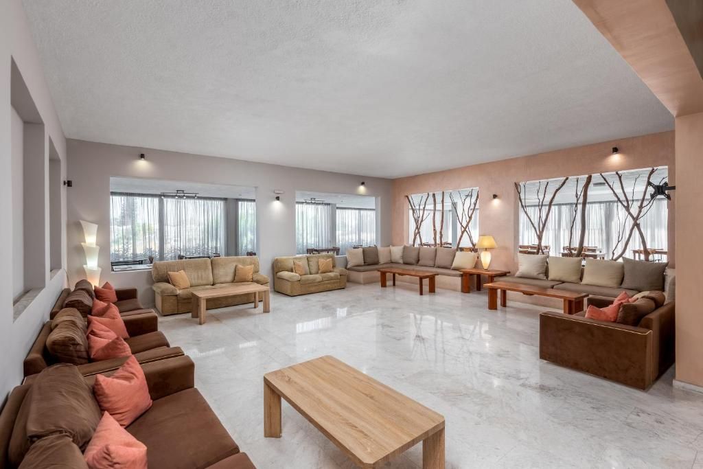 A spacious living room with multiple seating areas, large windows, and a modern design.