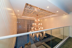 A modern interior with a large chandelier, a glass railing, and a patterned ceiling. - Bisetun Hotel (Istanbul)