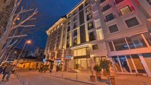 A multi-story hotel with a modern facade, large windows, and a visible entrance. - Bisetun Hotel (Istanbul)
