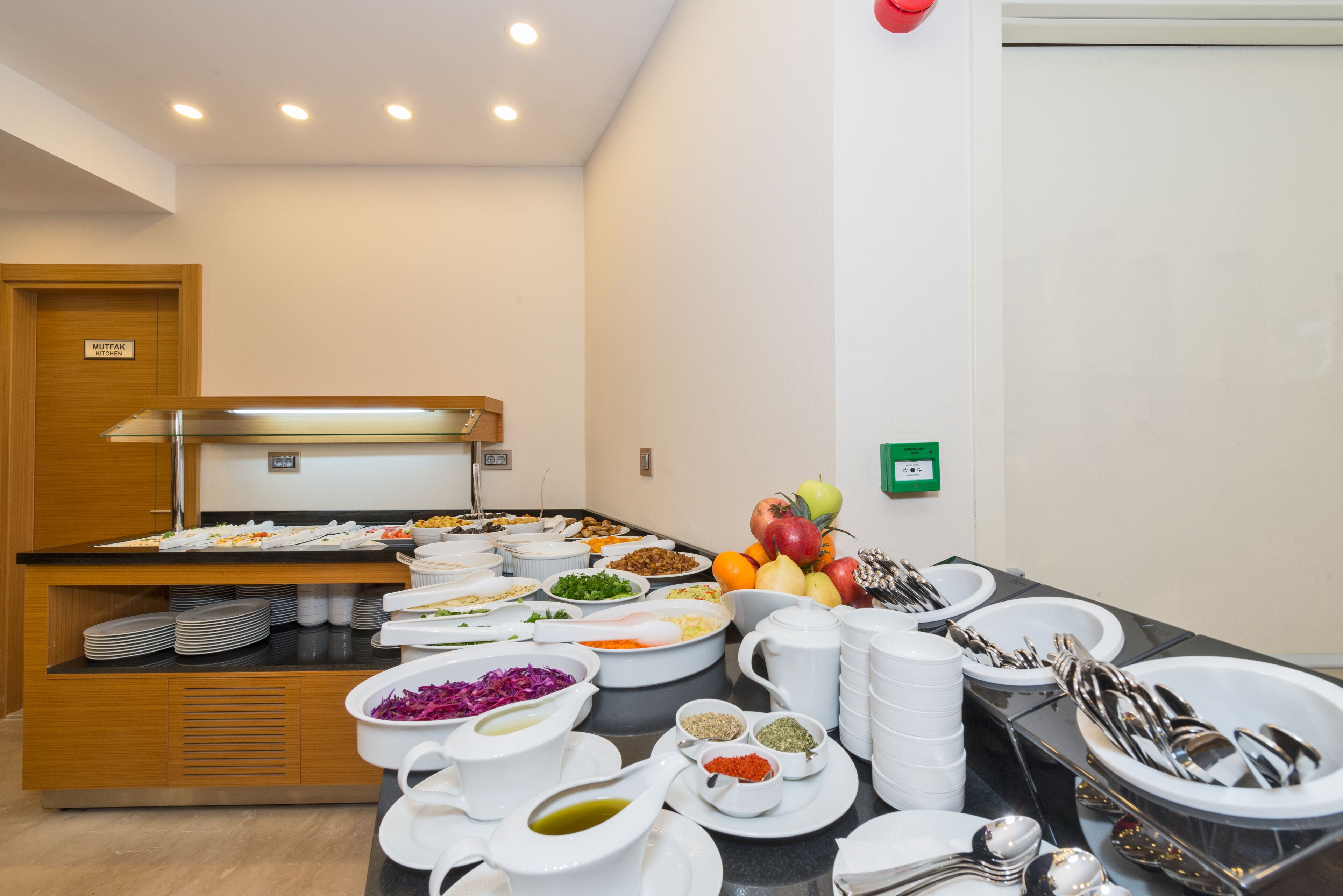 A buffet setup with various food items and serving utensils.