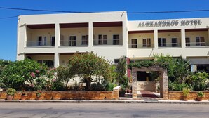 A two-story building with balconies, a sign reading "ALEXANDROS HOTEL," and a stone entrance. - Alexandros (SISSI)