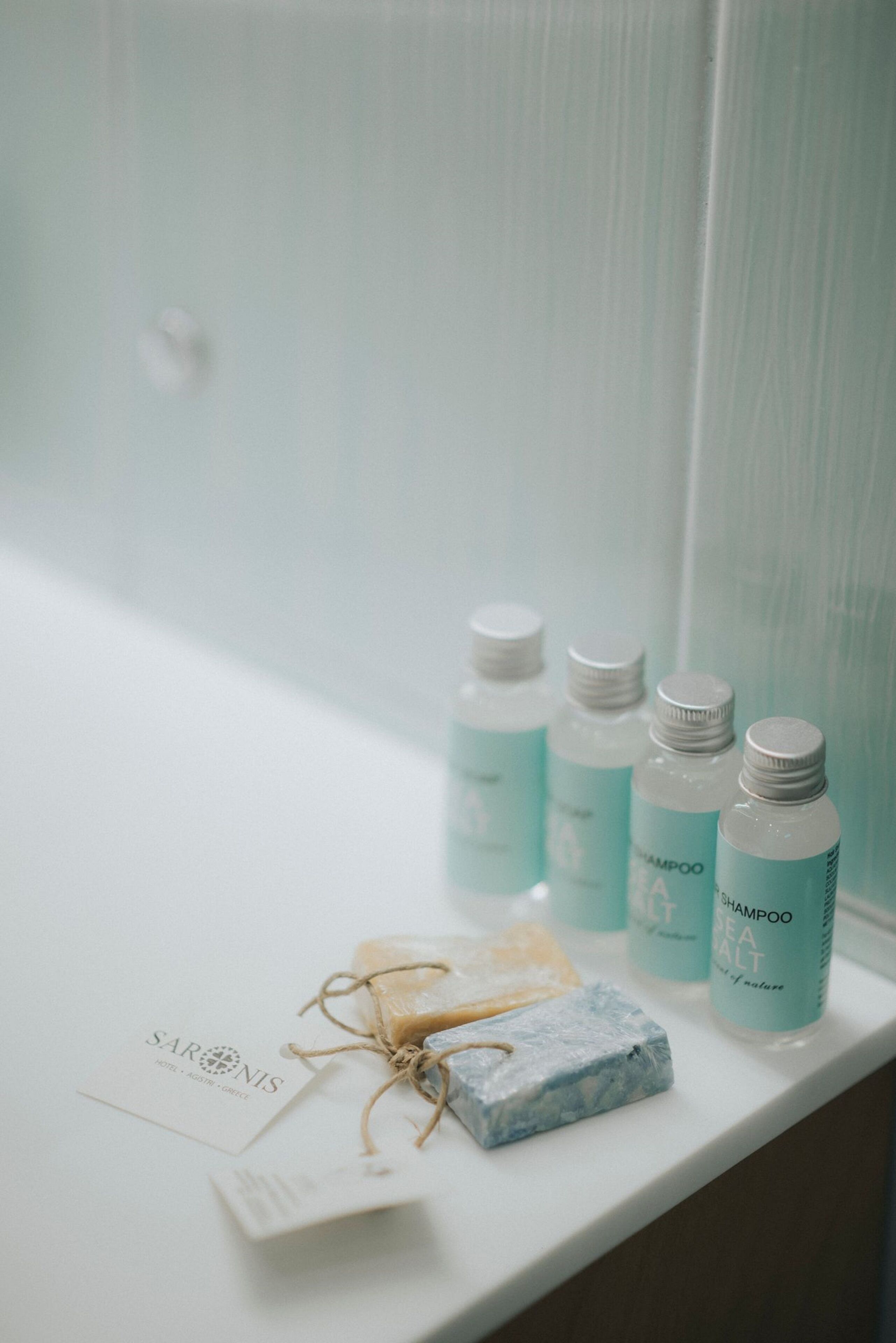 Un meuble-lavabo de salle de bain avec quatre bouteilles de shampoing et un savon.
