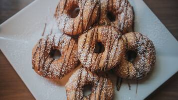 A plate of glazed donuts with powdered sugar.