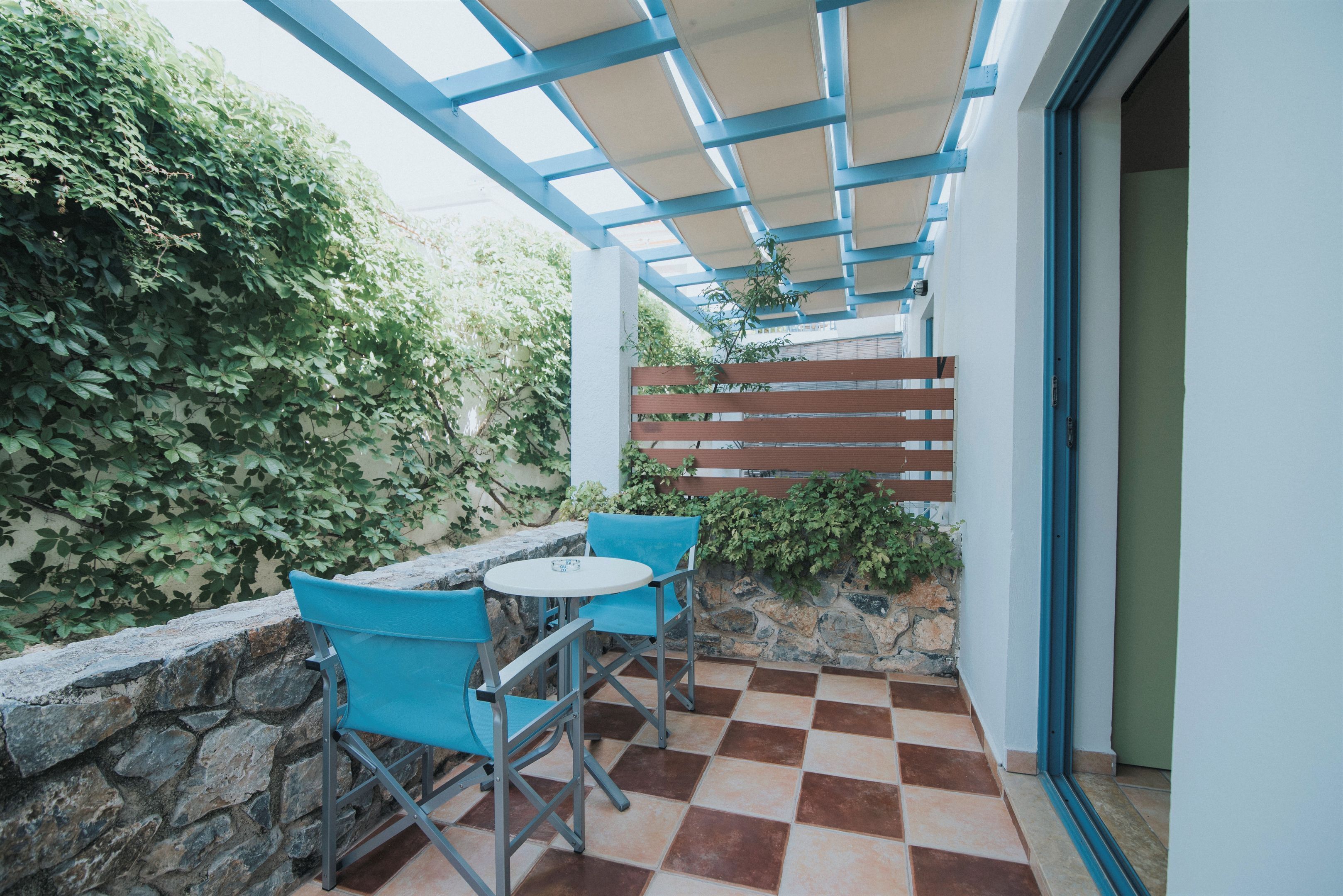 A covered outdoor seating area with stone walls and a checkered floor.