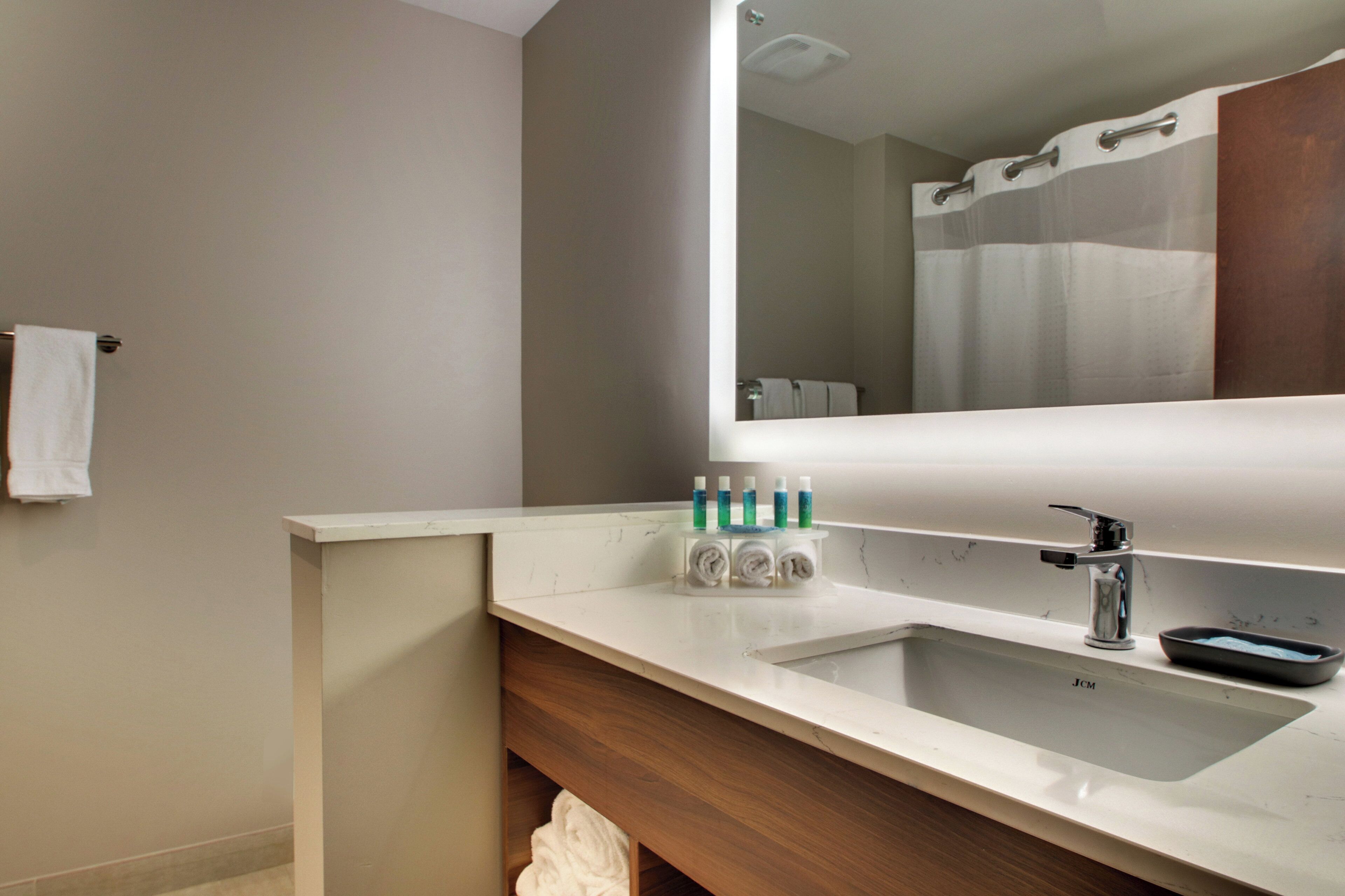 A bathroom with a white sink, a mirror, and a towel rack.