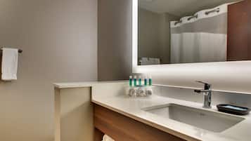 A bathroom with a white sink, a mirror, and a towel rack.