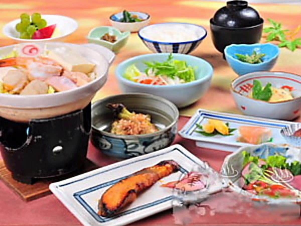 A variety of dishes including a large pot, bowls, and plates with food.